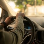 Vue du conducteur, mains sur le volant, tableau de bord et radio visibles